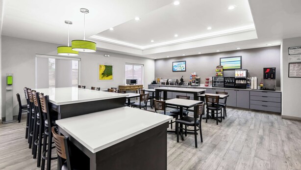 A modern kitchen with a central island, bar area, and seating.