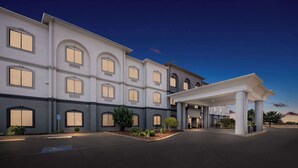 A large, multi-story hotel with a covered entrance and a landscaped driveway.