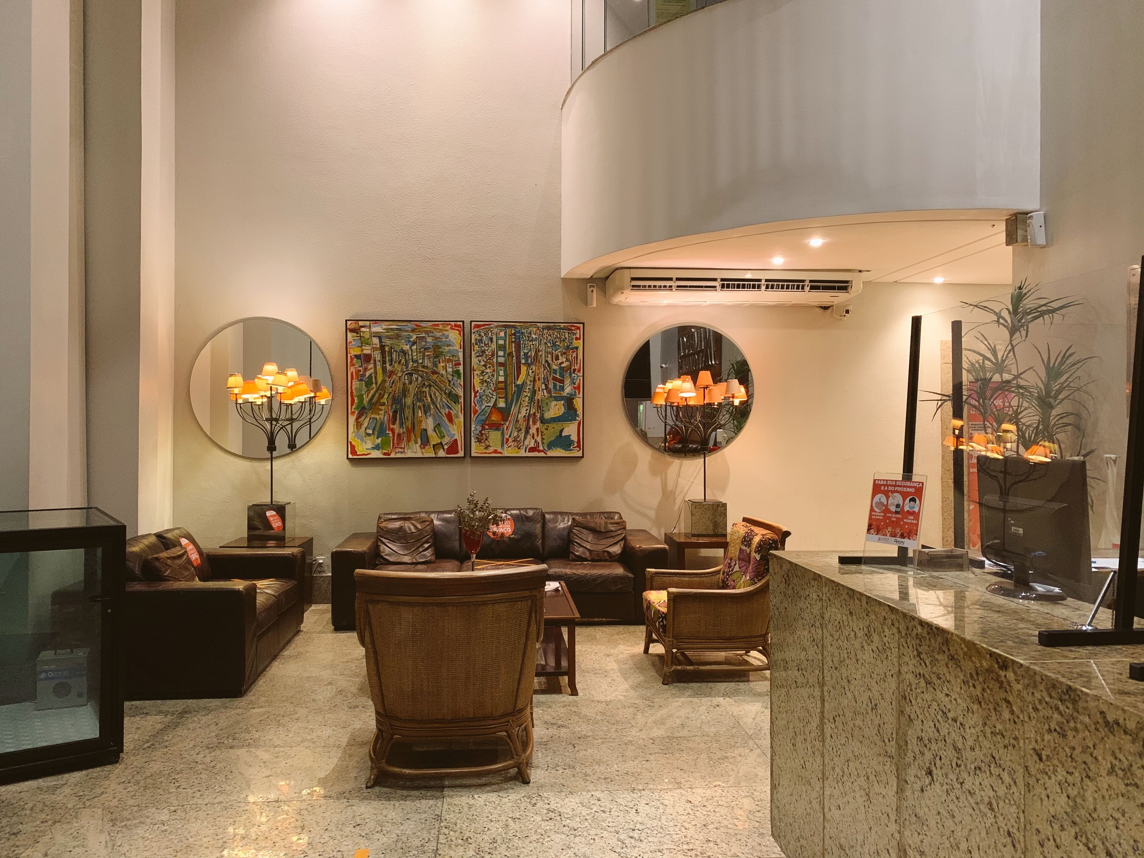 Un hall d’entrée moderne, doté d’un canapé, de fauteuils, d’une table basse et d’œuvres d’art accrochées aux murs.