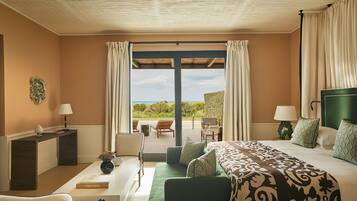 A hotel room with a bed, a desk, a chair, a sofa, and a view of the outdoors.