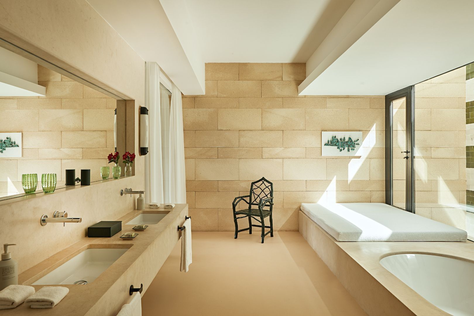 A modern bathroom with a large sink, mirror, and bathtub.