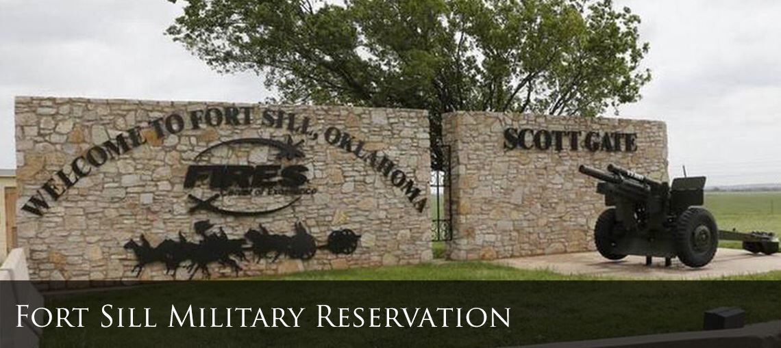 Une plaque de pierre portant l’inscription « Bienvenue à la réserve militaire de Fort Sill » et « Porte Scott », ainsi qu’une image d’un canon et d’une jeep.