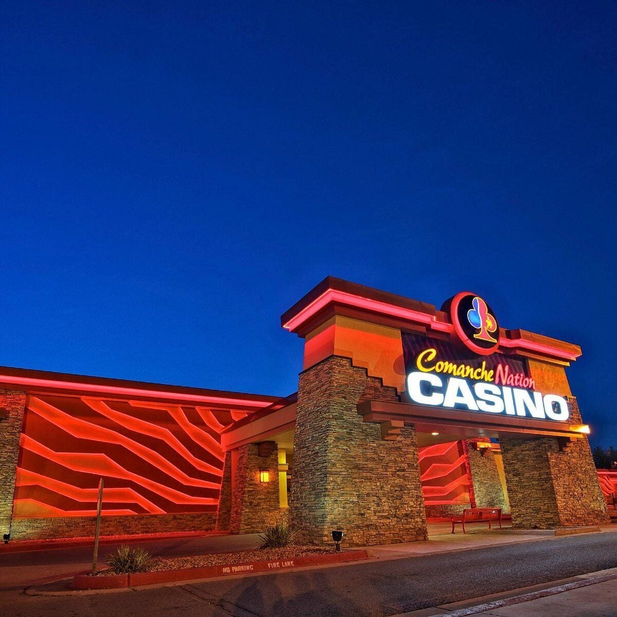 A casino building with a prominent sign reading "Comanche Nation CASINO" and a large illuminated logo.