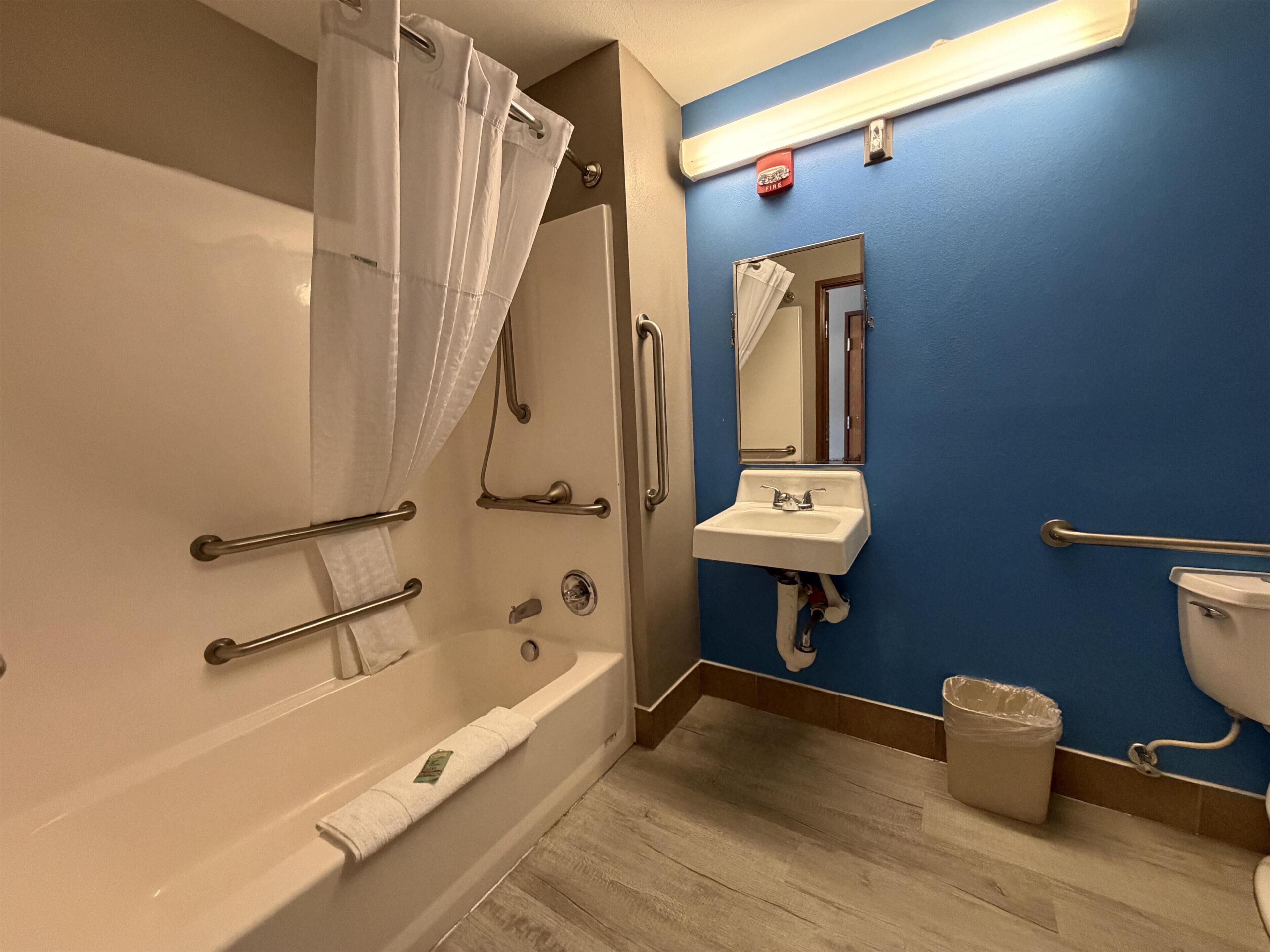 A bathroom with a bathtub, a sink, a toilet, and a shower curtain.