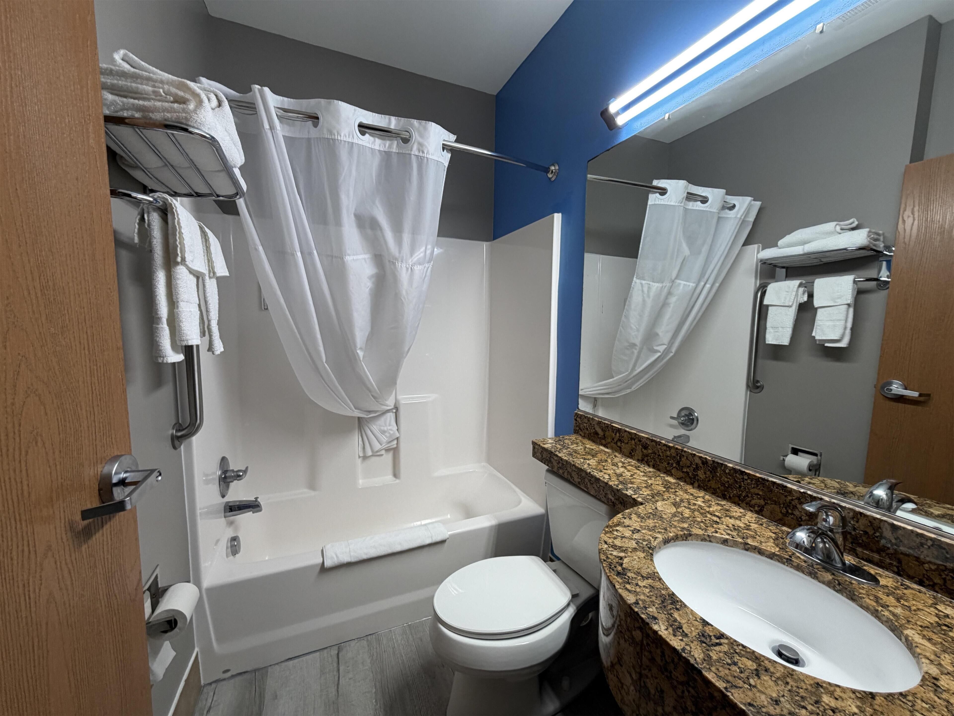 Ein modernes Badezimmer mit Badewanne, Toilette und Waschbecken.