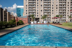 Une piscine avec vue sur un immeuble de grande hauteur en arrière-plan.