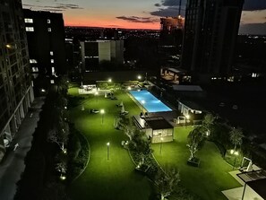 Relax by the pool surrounded by lush greenery and comfortable lounge chairs.