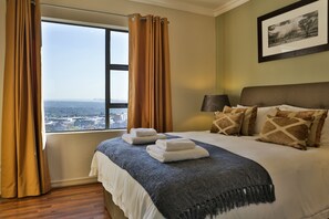 Relax in a spacious room with a large bed, patterned pillows, and a framed picture on the wall.