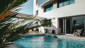 Piscine extérieure, parasols de plage, chaises longues