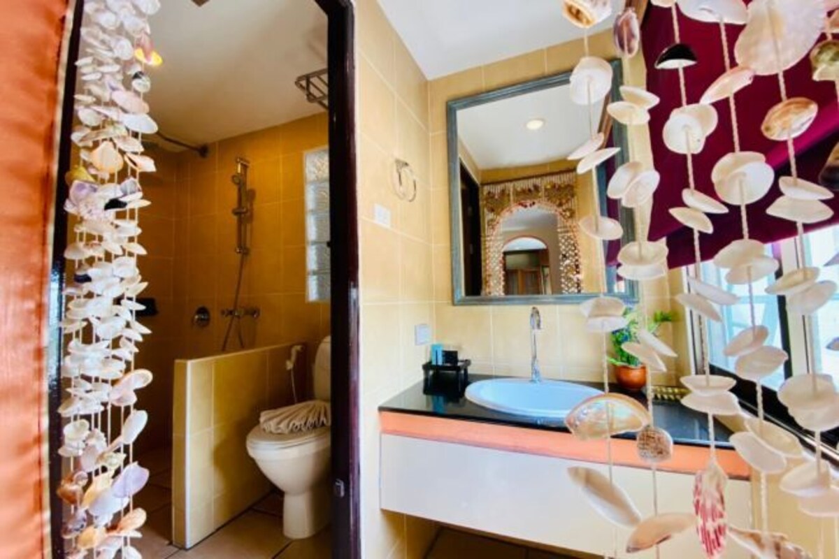 A bathroom with a beige sink, a mirror, and a shower.
