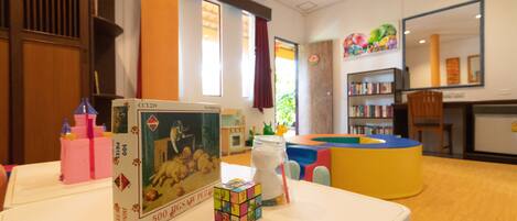 Un espace de jeux pour enfants comprenant un cube de puzzle, un bocal avec une paille et un livre intitulé « 500 puzzles ».
