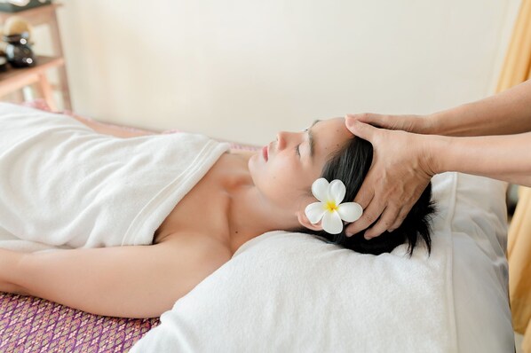 A person lying on a bed with a white pillow and a white towel, receiving a head massage. - Aochalong Villa Resort & Spa (Chalong)