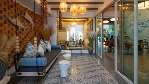 Un interior moderno con pared de madera, sofá azul, piso estampado y luces colgantes.