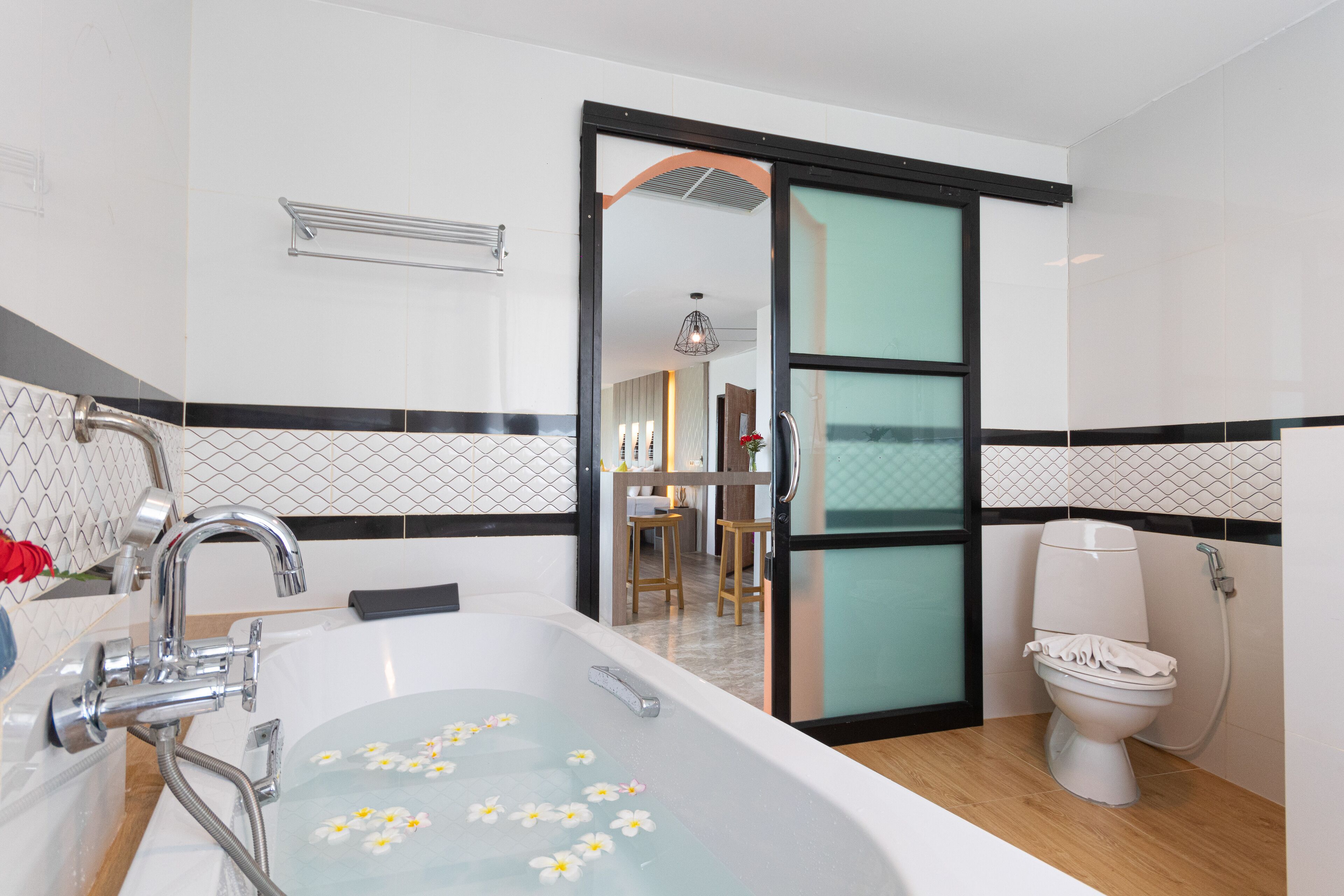 A modern bathroom with a bathtub, toilet, and shower.