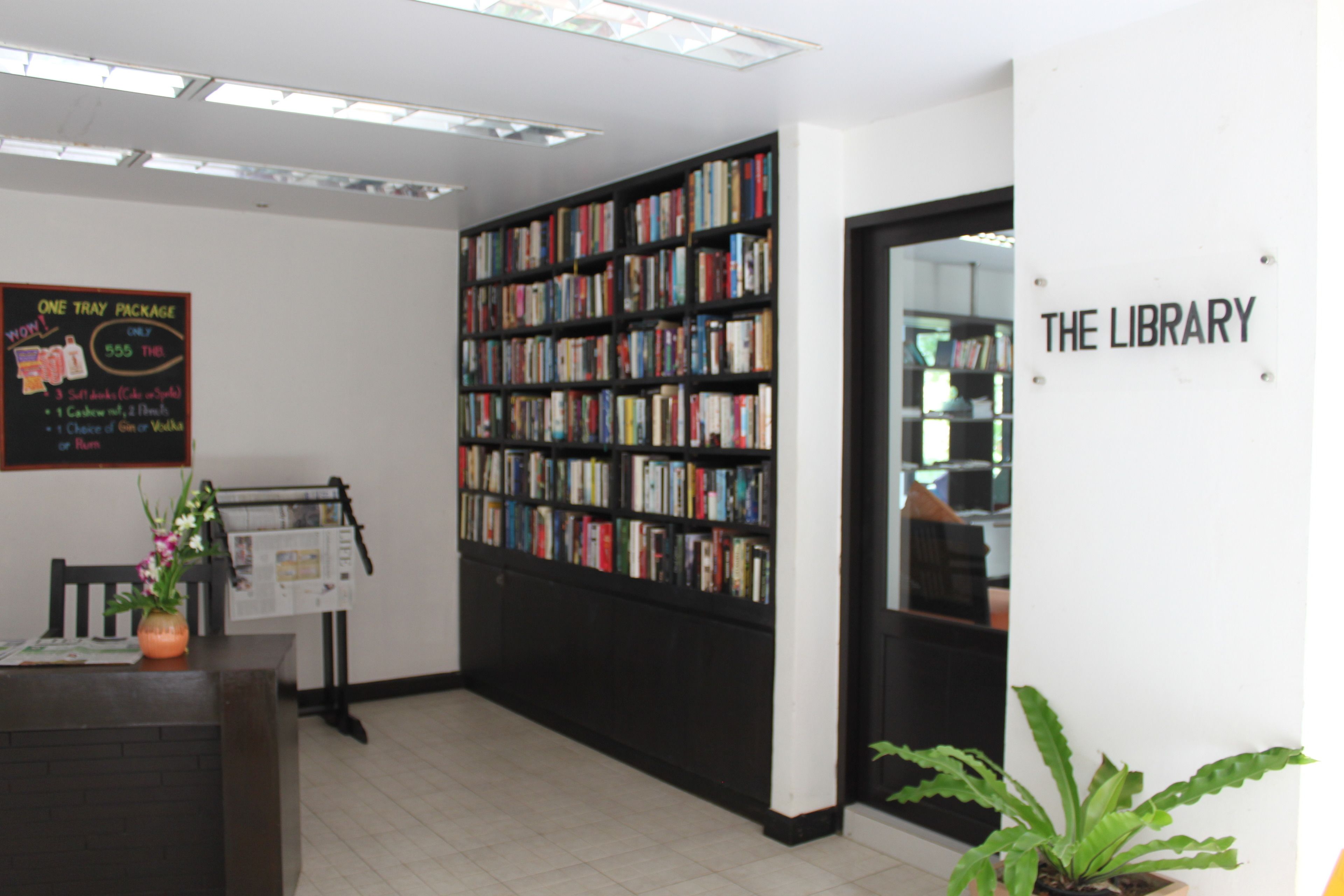 Interior de una biblioteca con una estantería, un letrero que dice 