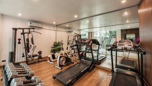 A gym with treadmills, weights, and exercise machines. - The Bedrooms Boutique Hotel (Bangkok)