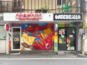 A storefront with a colorful mural, a sign for 'ARAWANA Express Phromphong', and a 'WEEDZILLA' sign. - Arawana Express Phromphong (Bangkok)