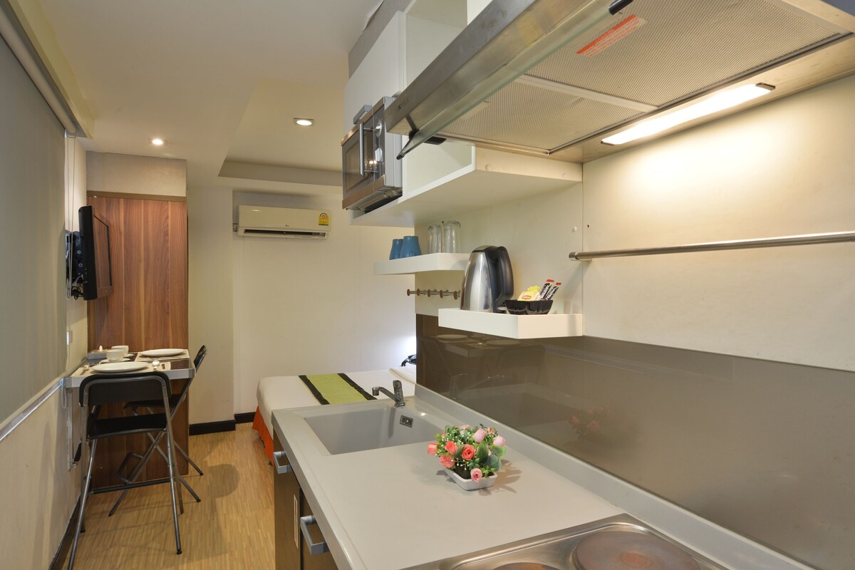 A compact kitchen with a sink, a small countertop, and a microwave.