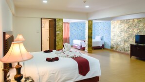 A hotel room with a large bed, a TV, and a lamp. - Pattaya Hiso Hotel (Pattaya)