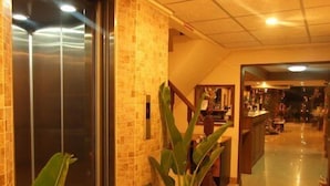 A hotel lobby with a reception desk, a staircase, and a potted plant. - Honey House 2 (Bangkok)