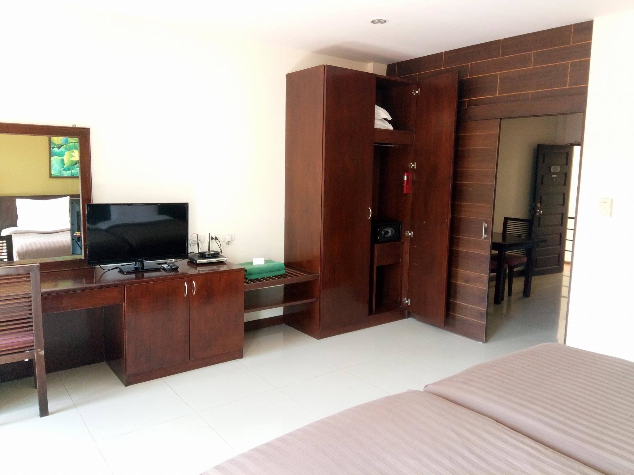 A hotel room with a bed, a TV, a desk, and a wardrobe.