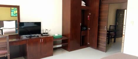 A hotel room with a bed, a TV, a desk, and a wardrobe.