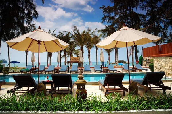 Una piscina al aire libre, sombrillas