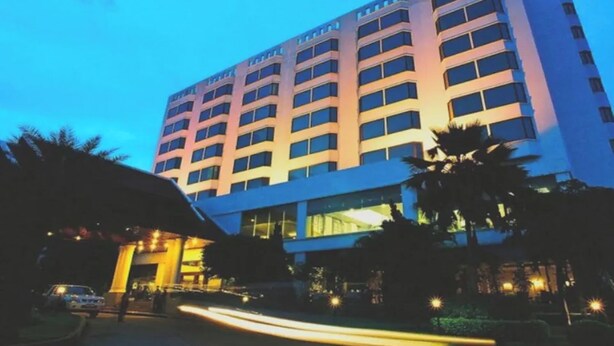 A multi-story hotel with a modern facade, large windows, and a well-lit entrance area.