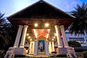 Un edificio con un acceso cubierto, columnas y estatuas.