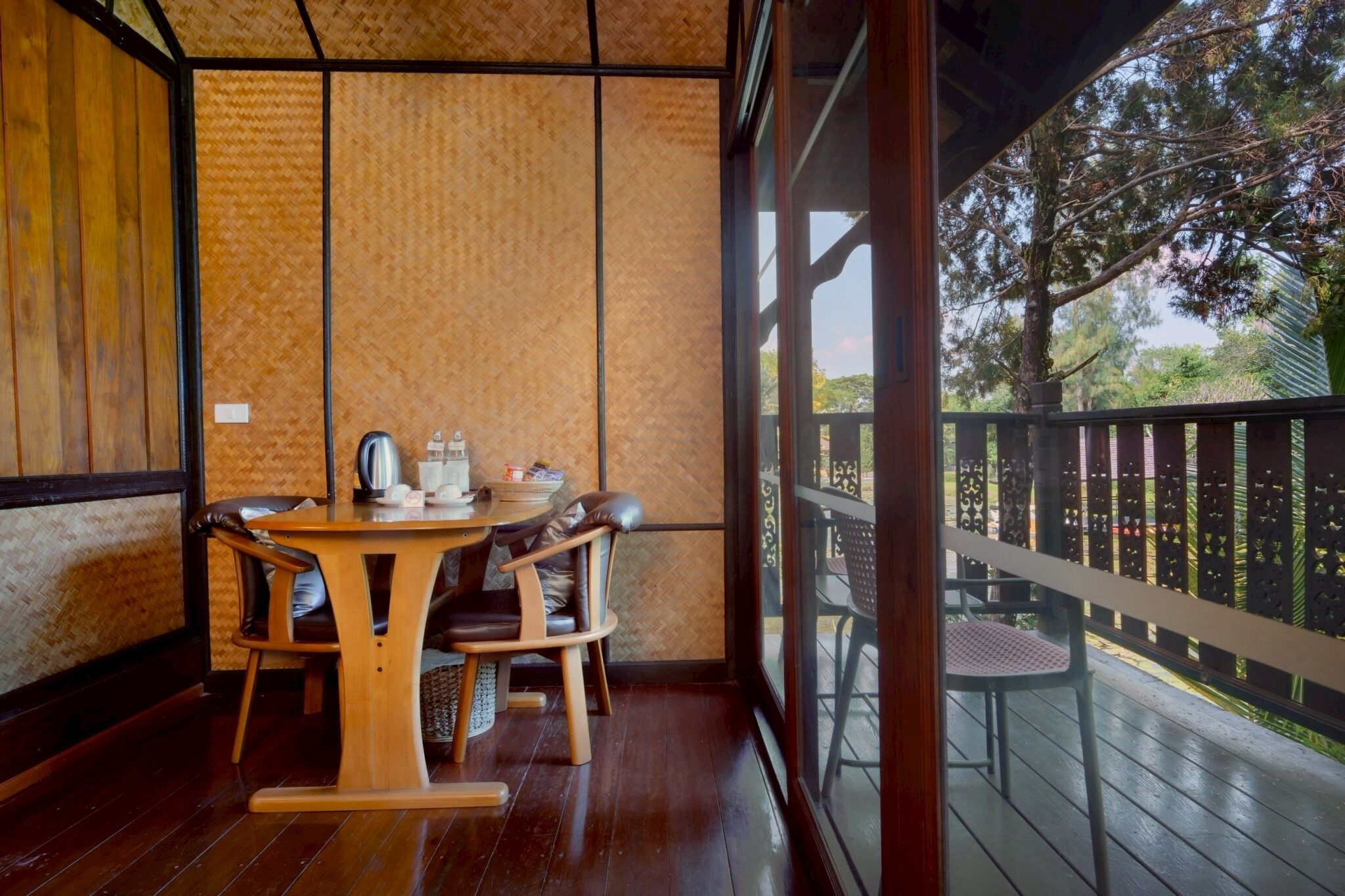 Una mesa de madera con sillas en una habitación con vista a un balcón.