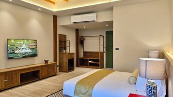 Ein modernes Hotelzimmer mit Bett, Fernseher, Kleiderschrank und Schreibtisch.
