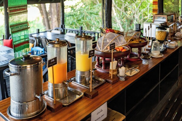 Montaje de un bufé de desayuno con diversos dispensadores de alimentos y bebidas.