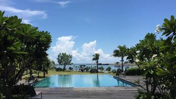 A clear blue sky, a swimming pool, and a view of the sea.