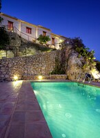 Una piscina al aire libre, sillones reclinables de piscina