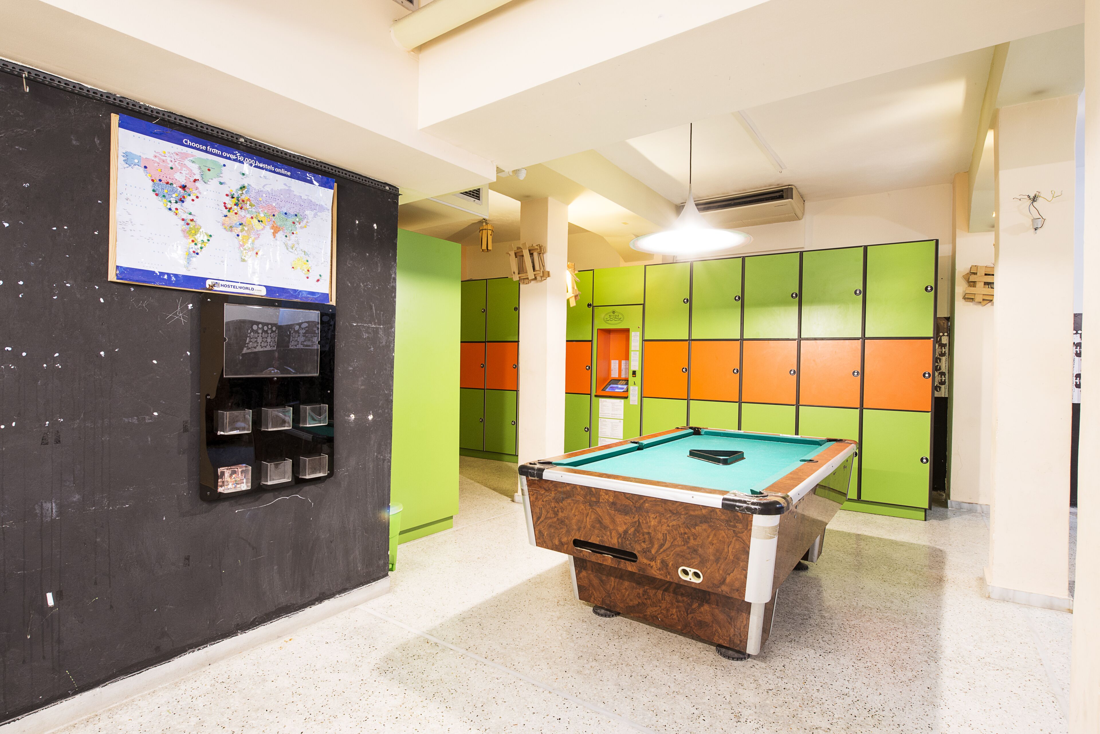 A pool table in a room with colorful lockers and a map on the wall.