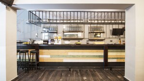 A bar area with stools, a counter, and a staircase. - Safestay Athens Monastiraki (Athens)