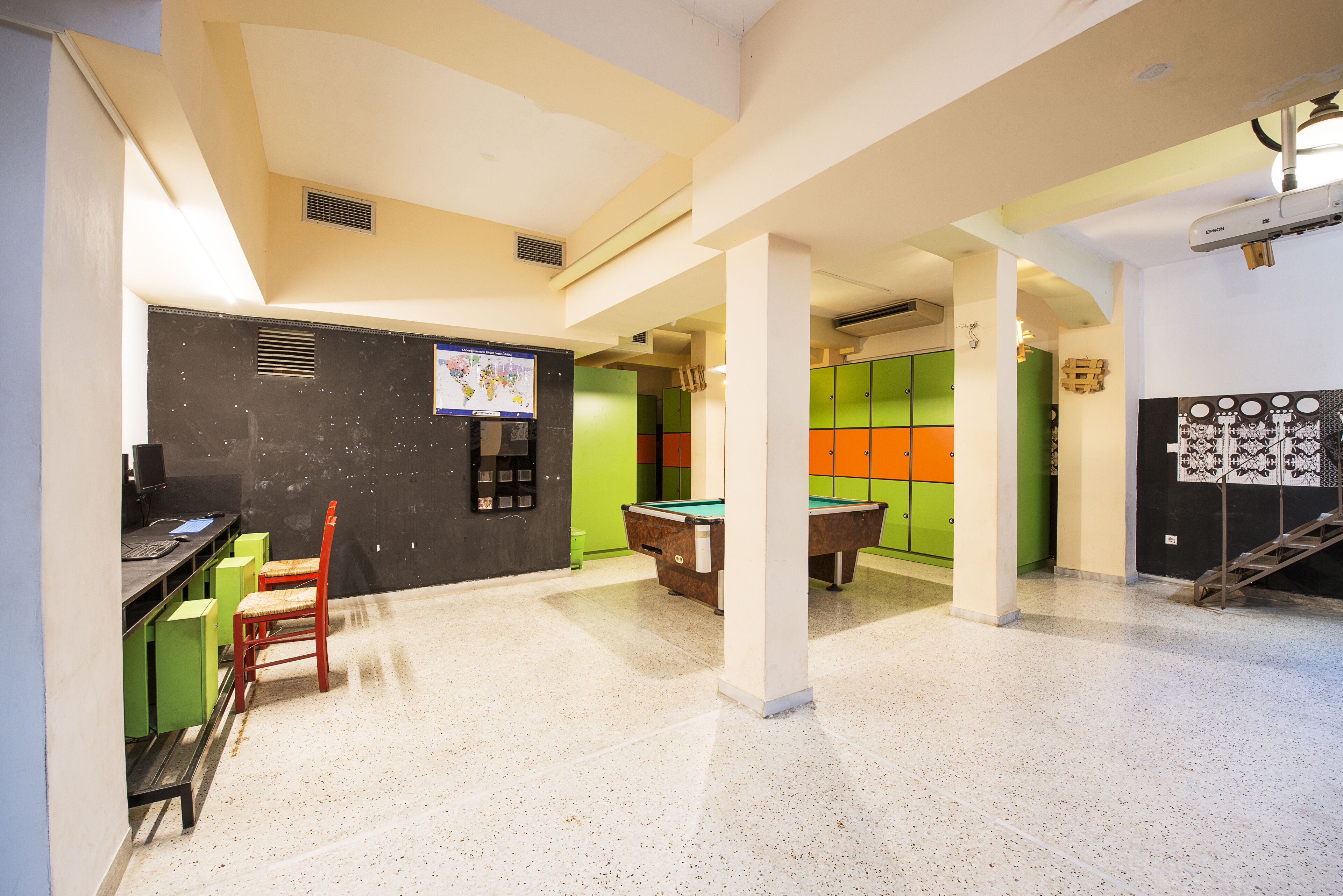 Una sala de bitlles amb billar, cadires i un ordinador.