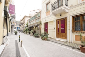 A narrow street lined with buildings, including a hotel with a prominent 'safestay' sign.