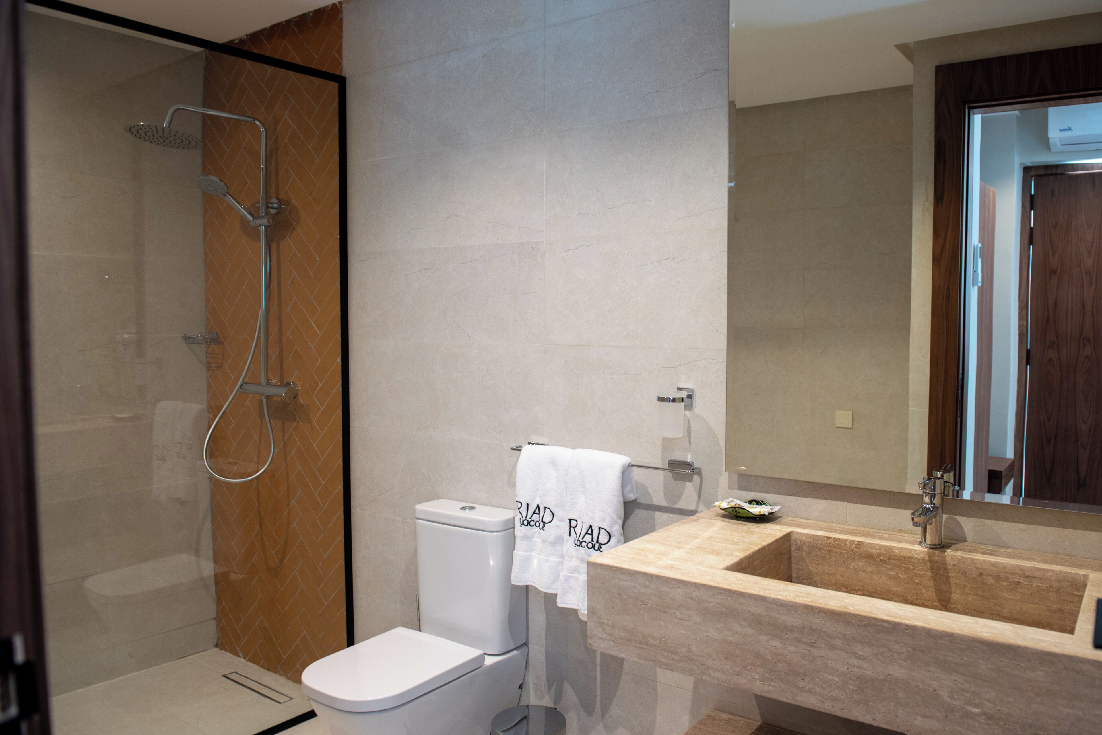 A modern bathroom with a shower, toilet, and sink.