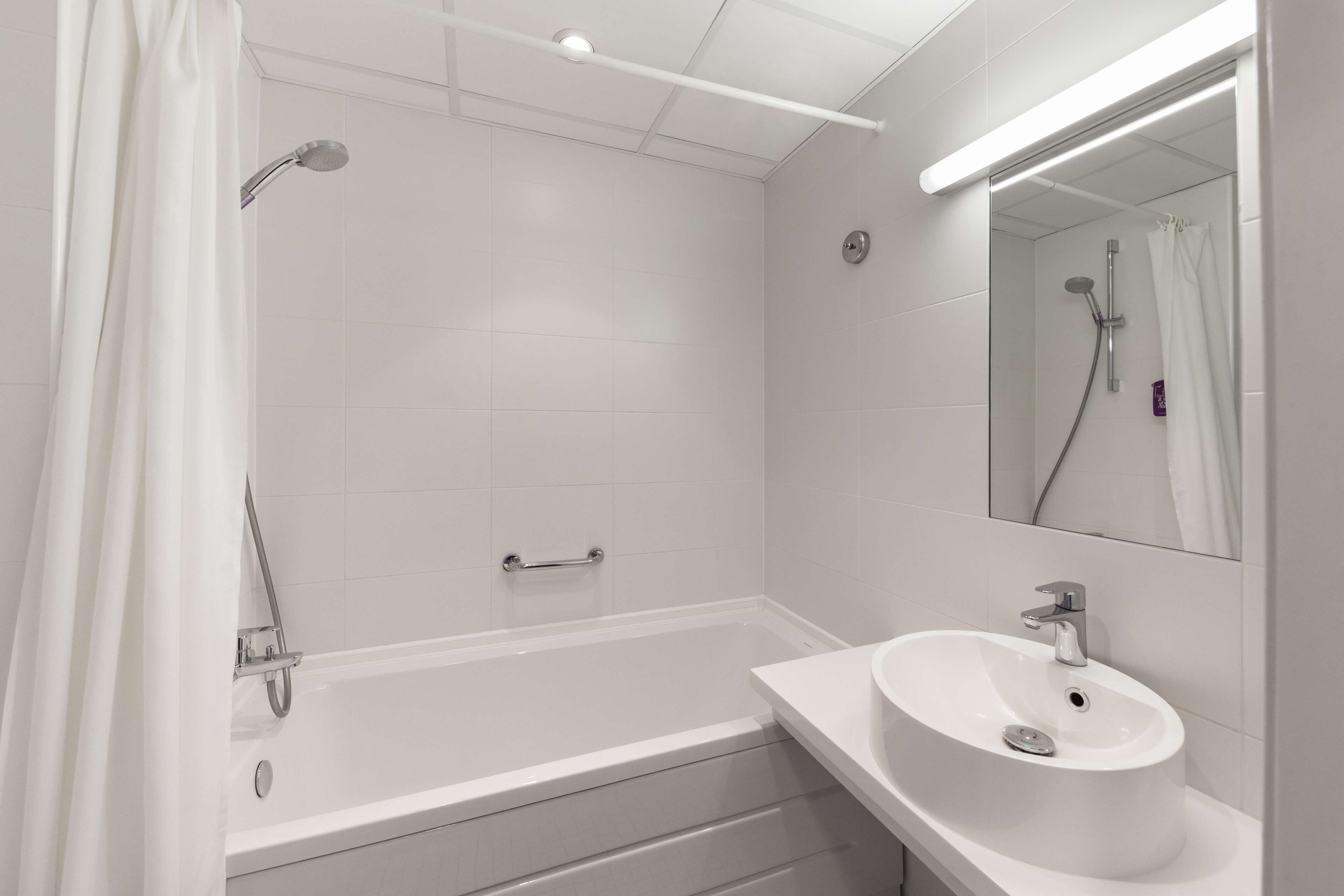 Un baño moderno con bañera, lavabo y espejo.