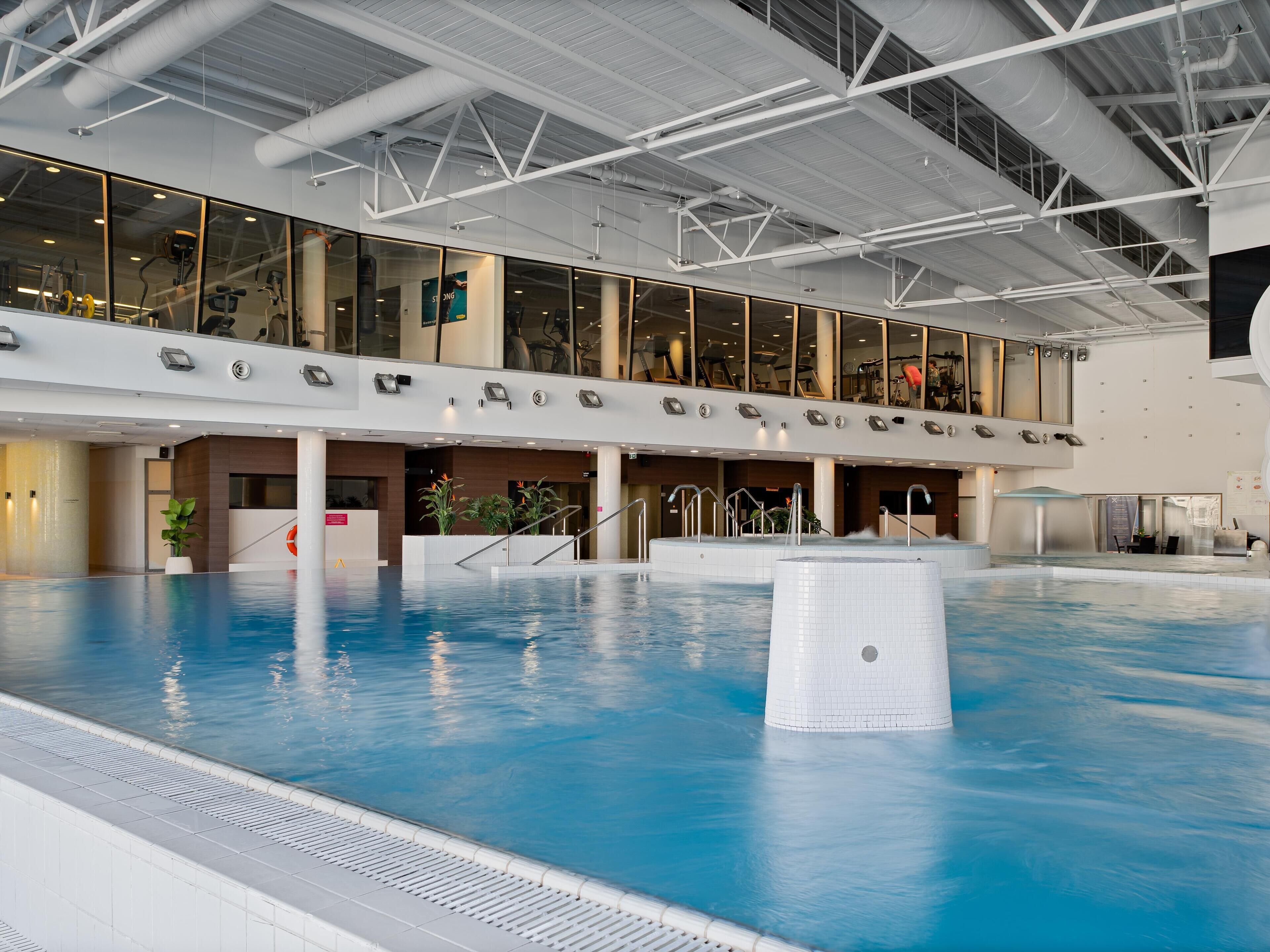 A large indoor swimming pool with a high ceiling and modern architecture.