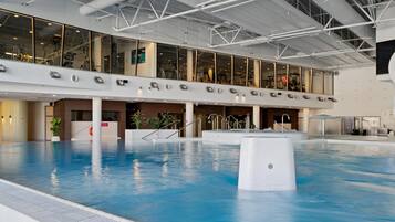 A large indoor swimming pool with a high ceiling and modern architecture.
