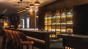 A bar area with a counter, bar stools, and a well-lit display of bottles. - Park Inn by Radisson Meriton Conference & Spa Hotel Tallinn (Tallinn)