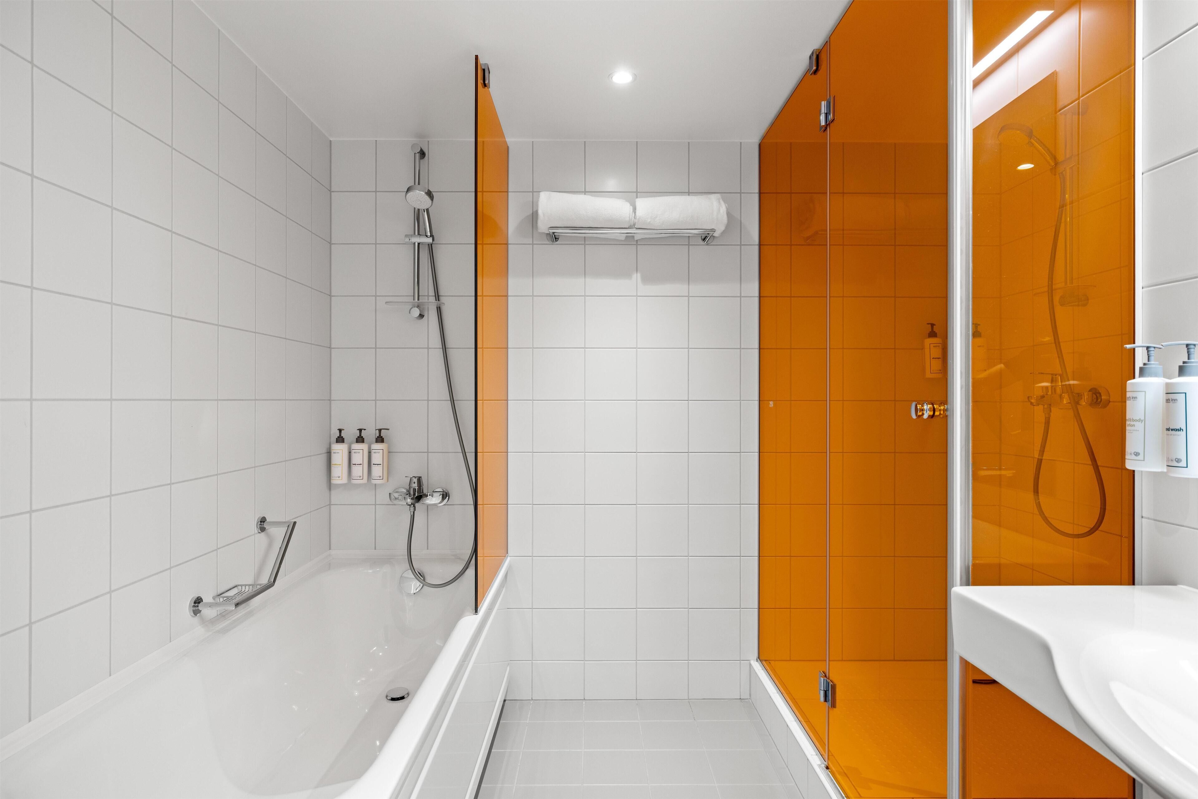Een moderne badkamer met een badkuip, douche en een douchecabine met glazen wanden.