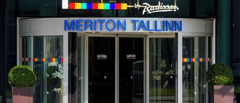 A hotel entrance with a revolving door, the name 'Park Inn' above, and 'Meriton Tallinn' below.