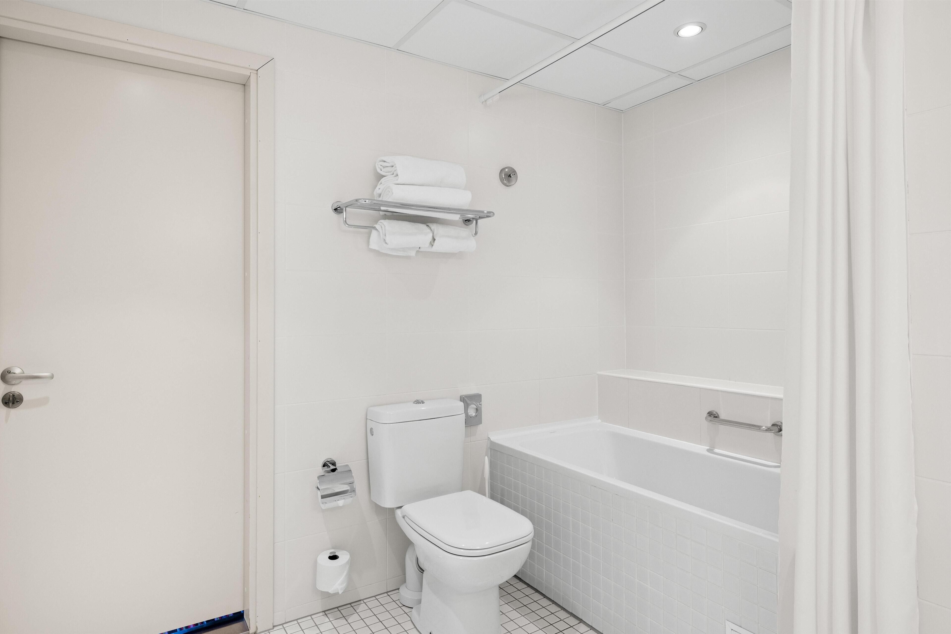 A small, white bathroom with a toilet, a sink, and a bathtub.
