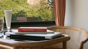 A laptop on a round table with a book and a glass of milk. - Takiab Beach Resort (Hua Hin)
