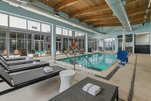A pool area with lounge chairs and a diving board. - Aloft by Marriott Bolingbrook (Bolingbrook)