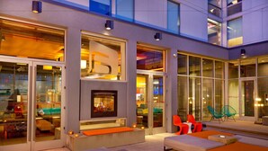 Un área de estar moderna con asientos, chimenea y ventanas amplias.