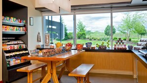 Una cocina moderna con un amplio ventanal, encimera de madera y diversos alimentos a la vista.